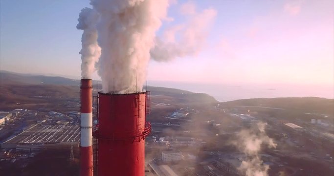 Great aerial panoramic view of Central Heating and Power Plant chimneys with steam rising from them. Vladivostok, Russia. Sunrise