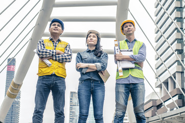 Mature engineer people in hard hats looking up at the site