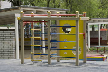 A children's playground, a slider located on the sand.