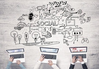 Top view of businesspeople sitting at table and using gadgets