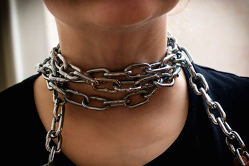 Photo of hands releasing the neck from a metal chain