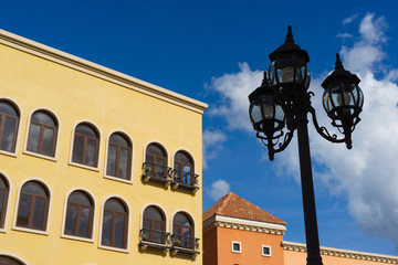 Fototapeta na wymiar Street lamps with yellow and red buildings on blue sky