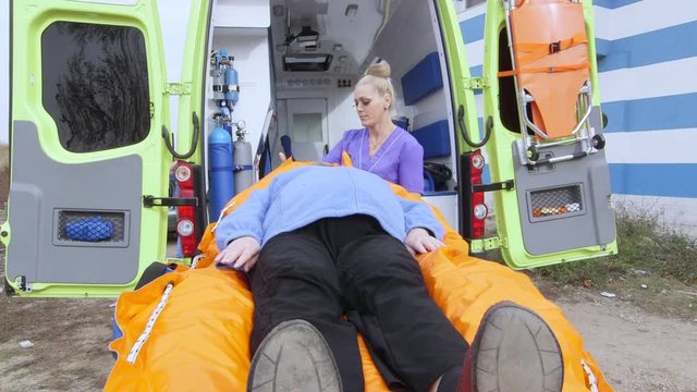 Emergency medical services. EMT professional provides emergency or non-emergency transportation. Patient transfer service. Paramedic is pulling stretcher with patient to the ambulance vehicle.