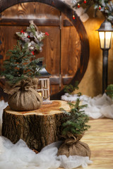vintage lantern, on a stump with live Christmas trees on the background of the door to the fairy...