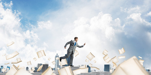 Precise businessman in suit running with phone.