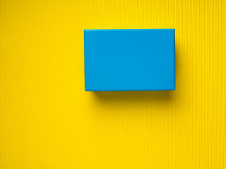 Closed Blue gift box on yellow background