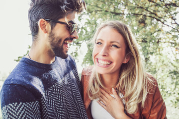 Happy couple in love having fun outdoors and smiling.