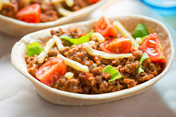 Stand n stuff tortillas with minced beed, tomatoes, lettuce and cheddar 