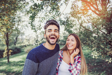Happy couple in love having fun outdoors and smiling.