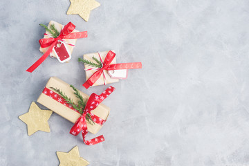 Flat lay top view christmas gifts with gold stars on grey concrete table. New year concept. Text space