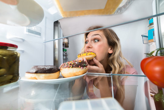 Happy Woman Eating Donut From Plate