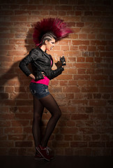 Punk girl on brick wall background
