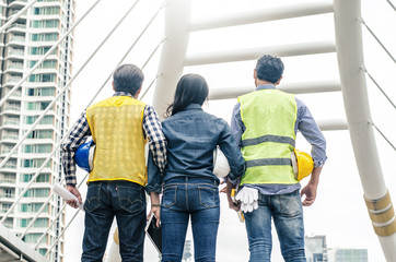 Back view of Asian young foreman and engineer looking up at the site