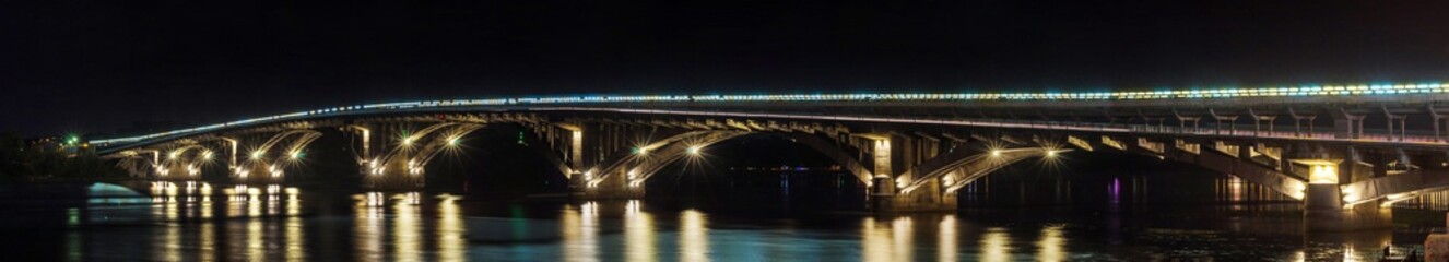 Night panorama of the Metro bridge across the Dnipro in Kyiv