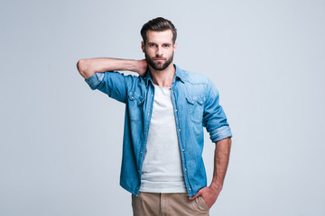 Can you stand this look? Handsome young man looking at camera while standing against white background