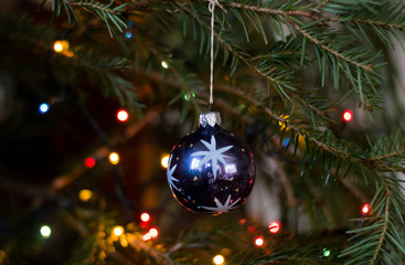 Fototapeta premium Old painted glass sphere with stars with soft focus on blurry bokeh christmas tree background