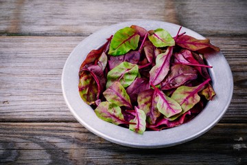 Fresh organic raw leaves of lettuce beets for salad on a wooden  background.