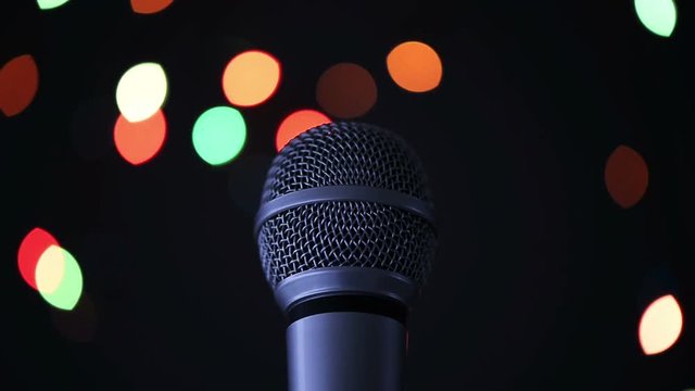 Audio microphone in karaoke bar with festive bokeh light background
