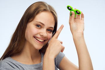 Young beautiful woman on white isolated background holds a green spinner