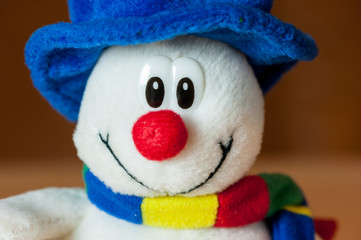 A cute little soft snowman with a blue hat and a colorful scarf