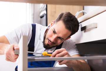 Male Carpenter Installing Drawer