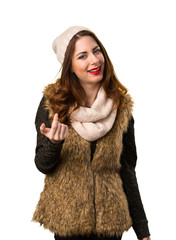 Girl with winter clothes doing coming gesture