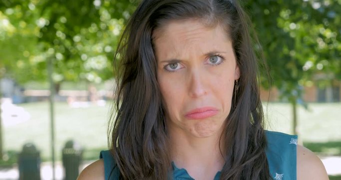 Sad unhappy upset woman pouting and frowning and looking at camera