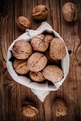 whole walnuts on old wooden rustic background.