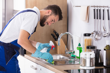 Man Cleaning Kitchen Worktop