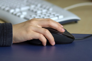 Kinderhand mit PC-Maus und Tastatur