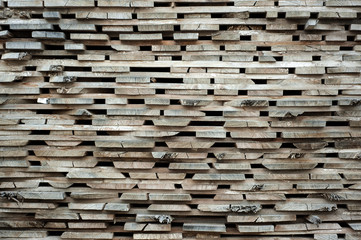 Folded wooden brown and gray planks in a sawmill. Piled alder boards as texture for design.