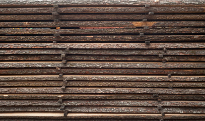 Folded wooden brown and gray planks in a sawmill. Piled alder boards as texture for design.