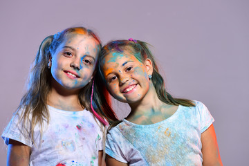 Schoolgirls have paint spots on faces and Tshirts.