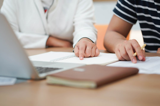 Close Up Teacher Pointing On Notebook For Teaching Lesson To Student (one By One) Before Test Examination, Educational Concept 