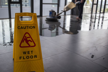 The people cleaning floor with machine.