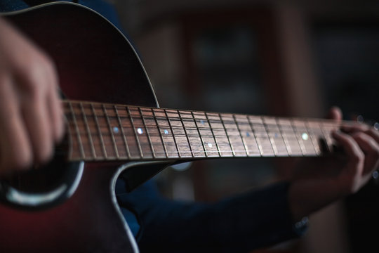 the guy playing the acoustic guitar, closeup, music concept