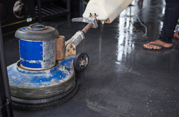 The man cleaning floor with machine.