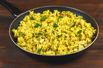 Indian biryani with chicken, yogurt and spices in a plate on a wooden table. New Year's, Christmas dish.