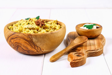 Indian biryani with chicken, yogurt and spices in a plate on a wooden table. New Year's, Christmas dish.