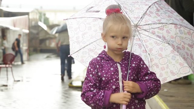 A little girl is standing with an umbrella in the rain. Confusion in the form of hiccups.