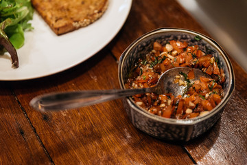 Tomato Salsa Sauce prepare for pasting toast in stainless steel cup with spoon.