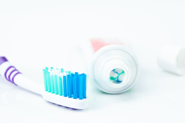 A tube of toothpaste and a toothbrush on white background