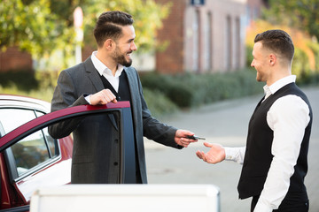 Young Businessman Giving Car Key To Valet