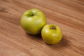 Two green apples on wooden table