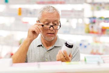 senior male customer with drug at pharmacy