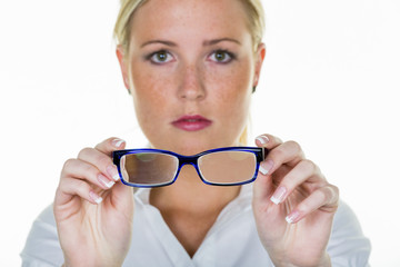 woman is holding a pair of glasses