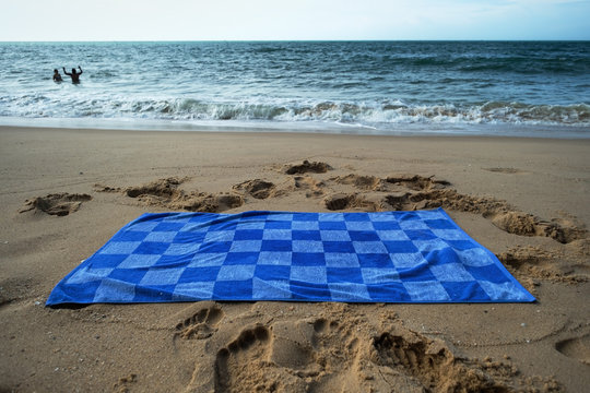 Blue towel on sandy beach. Concept of having good vacation in warm tropical country