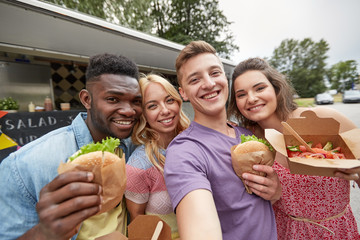 happy friends taking selfie at food truck