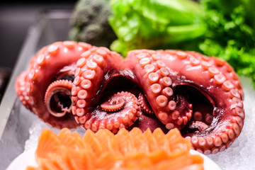 Fresh tentacles of octopus on the ice as a ingredients
