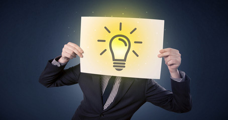Businessman holding paper with lightbulb